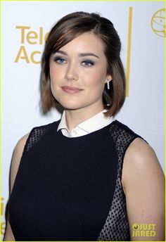 an image of a woman with short hair and blue eyes wearing a black dress on the red carpet