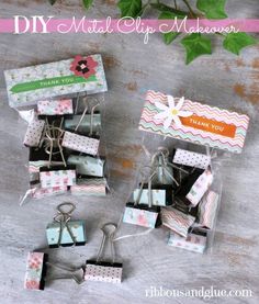 several small gift boxes with tags attached to them and some flowers in the back ground