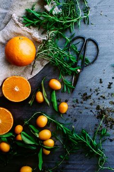 oranges and herbs on a table with scissors