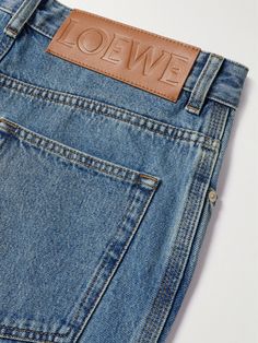 Designed in 1970 by Spanish painter Vicente Vela, Loewe's 'Anagram' motif comprises four cursive 'L's inspired by the folded metal of branding irons. Cut straight from denim, these jeans are embroidered with cotton emblems on each knee. Loewe Jeans, Cursive S, Applique Jeans, Loewe Anagram, Tag Jeans, Latest Jeans, Jeans Logo, Embellished Jeans, Leather Label