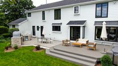 a large white house with an outdoor patio and grill