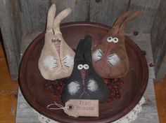 two stuffed rabbits sitting on top of a bowl