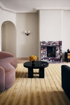 a living room with two couches and a coffee table in front of a fireplace