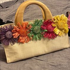 a handbag with flowers on it sitting on a bed