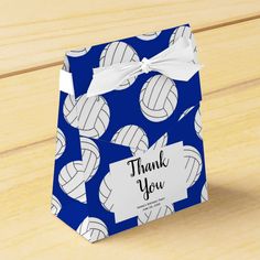 a blue and white volleyball themed gift bag with a thank you tag on the front