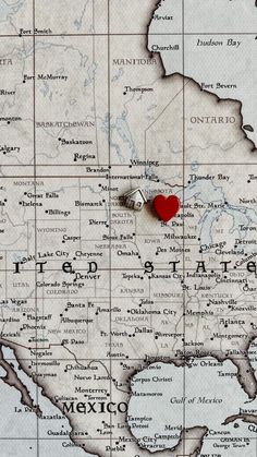 a map with a pin in the middle of it and a red heart on top