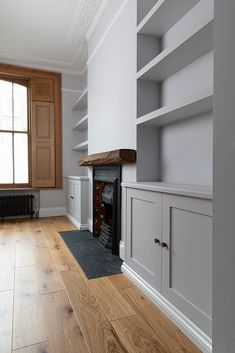 an empty living room with wood flooring and built - in bookshelves on the wall