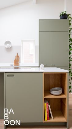 a kitchen with green cabinets and white counter tops