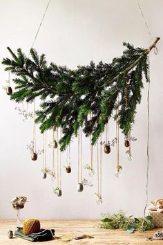 a christmas tree with ornaments hanging from it's branches and other decorations on the table