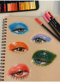 an open notebook with colored pencils and crayons next to it