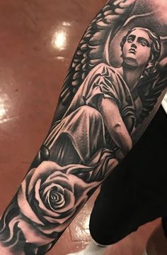 a man's arm with an angel and rose tattoo design on the left forearm