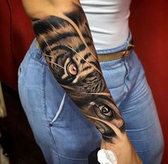 a woman with a tiger tattoo on her arm and the eye is in the background