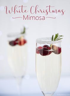 two glasses filled with white christmas mimosa and garnished with strawberries