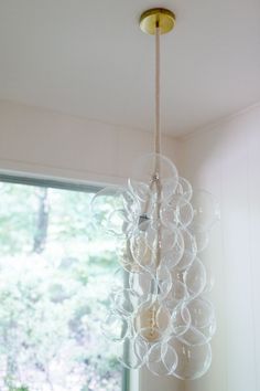 a chandelier hanging from the ceiling in front of a window