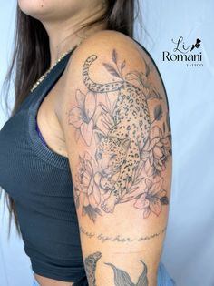 a woman with a leopard and flowers tattoo on her arm