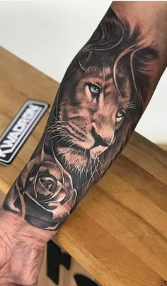 a man with a lion and rose tattoo on his arm