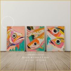 three colorful fish paintings on canvases in an empty room with wood flooring and white walls