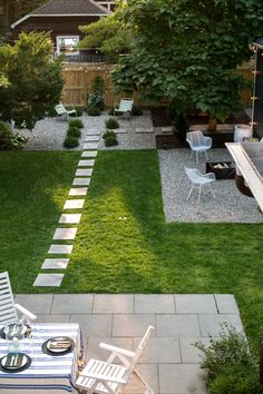 an outdoor patio with chairs, table and fire pit in the middle of grass area