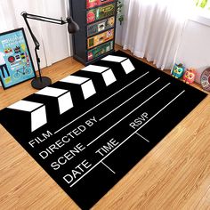 a black and white movie clapper rug on the floor in front of a window