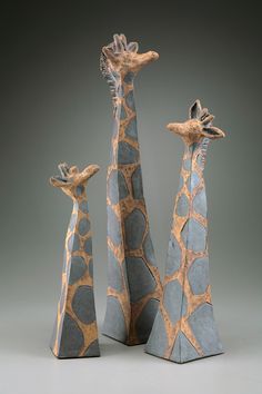 three giraffes are standing next to each other on a gray tablecloth