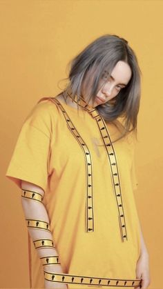 a woman with grey hair wearing a yellow shirt