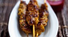 chicken skewers with toothpicks on a white plate