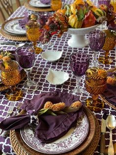 the table is set with purple and white dishes