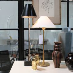 a lamp sitting on top of a table next to two vases