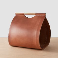 a brown leather bag sitting on top of a wooden table