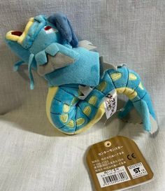 a blue and yellow stuffed animal next to a tag