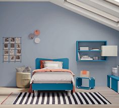 a bed room with a neatly made bed next to a blue shelf and bookcase