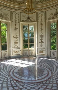 an ornate room with two windows and a circular floor tile design on the wall in front of it