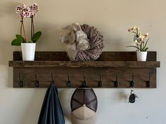 there is a shelf that has some flowers on it and two hats hanging from the hooks