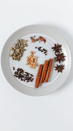 an assortment of spices on a plate with star anise, cinnamon and cloves