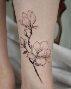 a woman's foot with a flower tattoo on it