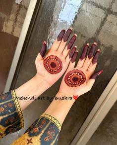 two hands with red and gold designs on them