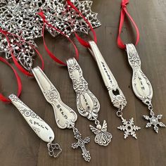 several silver items on a table with red ribbons