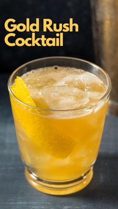 a close up of a drink in a glass on a table with the words gold rush cocktail