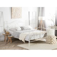 a white bed sitting on top of a wooden floor