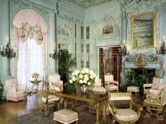 an ornately decorated living room with white and gold furniture