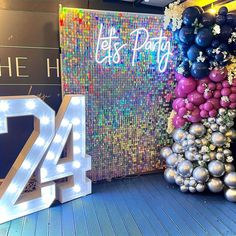 the number twenty forty four is displayed in front of balloons and streamers on display