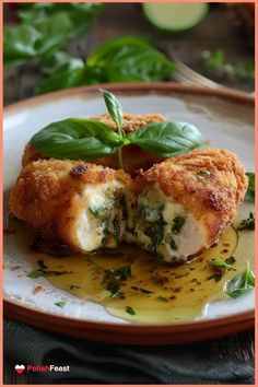 a white plate topped with chicken covered in sauce and garnished with green leaves