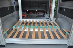 the back end of a van with its cargo door open and wood slats in place