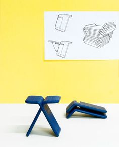 two blue plastic chairs sitting next to each other on a white table with a yellow wall in the background