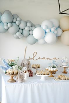 a table topped with lots of desserts and balloons