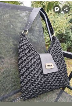 a handbag sitting on top of a chair in front of some bushes and trees