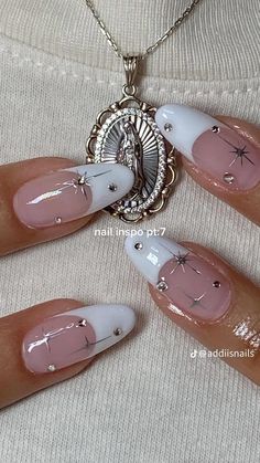 the woman is wearing white and pink nails with silver decorations on it's fingers