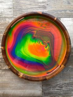 a wooden bowl with multicolored paint on it