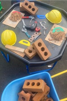 construction materials are arranged on top of a blue tray in front of a yellow hard hat