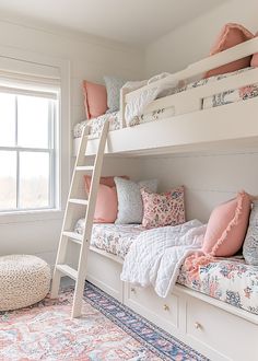 a bedroom with bunk beds and pillows on top of them, next to a window